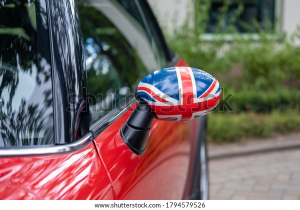 side window showing uk flag on red car with\
tinted windows