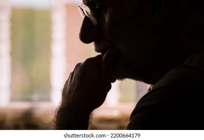 Sideview Of Adult Man With Glasses Using Laptop In Room