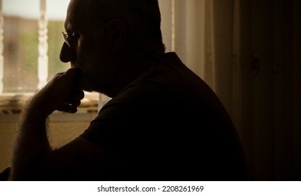 Sideview Of Adult Man With Glasses Using Laptop In Room