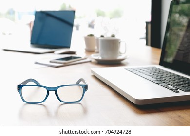 Sideview Of Office Desk With Laptop, Glasses And Other Items