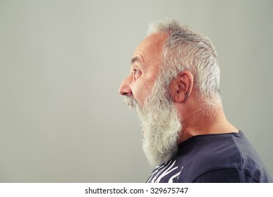 sideview portrait of screaming senior man with grey-haired beard 