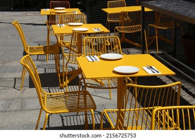 Sidewalk cafe in Poland. Warsaw, Poland. Modern hipster cafe with yellow steel chairs and table outdoor.