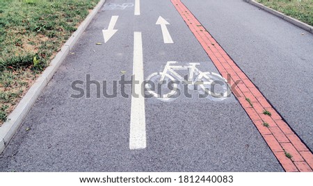 Sidewalk with cyclist path with white arrows divited to pedestrian and bike lane separated by Braille block road in Prague suburban area, the bicycle sign is repainted, Czech Republic, Europe (EU)