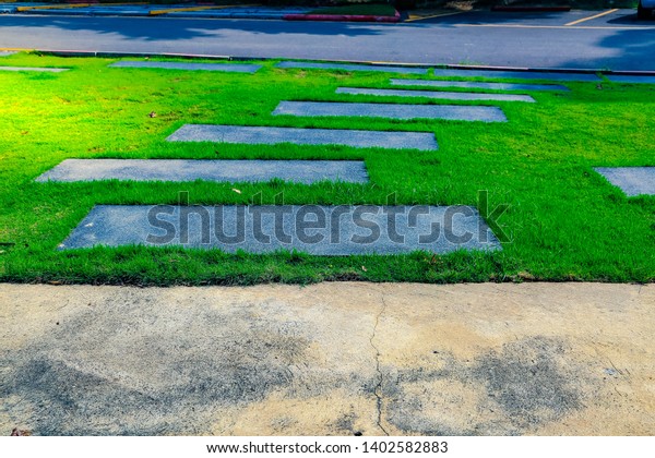 The sidewalk road in the\
background And is pathway combined with walkways that are covered\
with grass, gravel, painted on the road, divided into parking\
spaces.