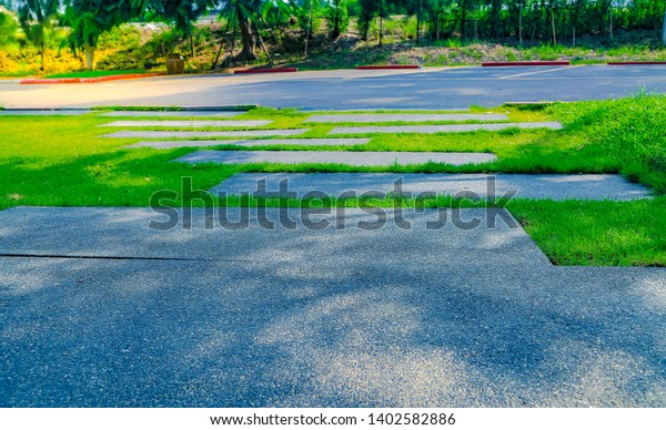 The sidewalk road in the\
background And is pathway combined with walkways that are covered\
with grass, gravel, painted on the road, divided into parking\
spaces.