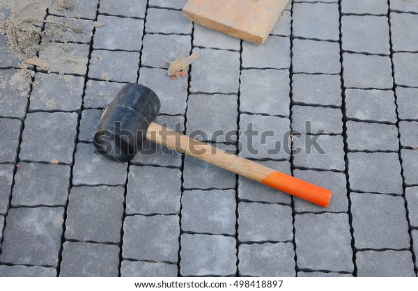 The Sidewalk Tiles. Mason tool for\
curb stone and brick pavement laying down, rubber\
mallet.