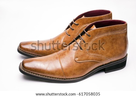 Sideways brown chukka boots on a white background