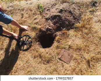 Siedlce, Poland - September 16 2020: A Metal Detector.  A Child With A Detector Is Standing Next To A Hole In The Ground, A Metal Plate Dug Out Next To It.