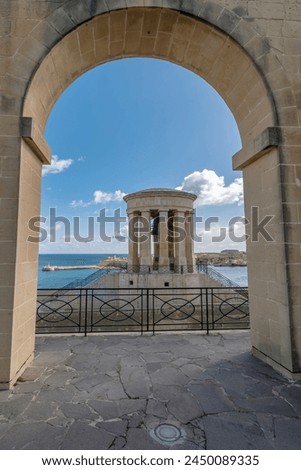 The Siege Bell War Memorial framed by an arch of the Lower Barrakka Gardens, Valletta, Malta
