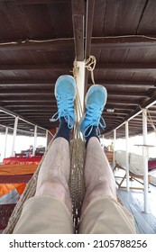 Siem Reap, Cambodia, 17 February 2017, Relaxing In A Hammock On Board Of A Boat On Lake Tonle Sap, Brown Shorts, Hairy Legs, Black Socks And Blue Sneakers, Symbol Of Serenity, Rest And Relaxation