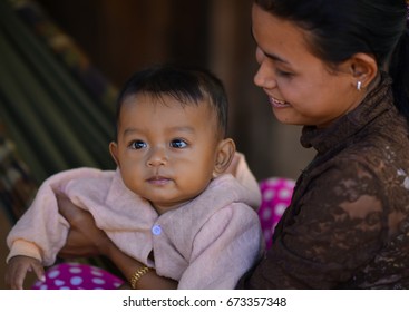 Siem Reap, Cambodia - Circa December 2011 - A close up portrait shot of an unidentified Cambodian woman and her child at the day market in Siem Reap, Cambodia