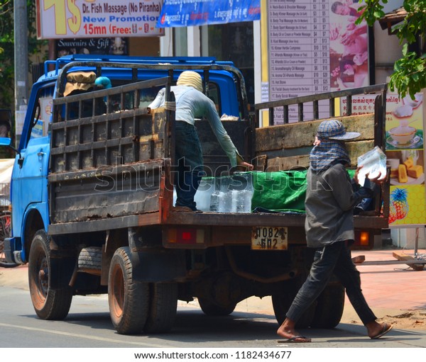 SIEM REAP, CAMBODIA MARCH 27\
2013: Young man delivery ice a the market  Cambodia. Because lack\
of refrigeration in Cambodia, ice is manufactured\
centrally.