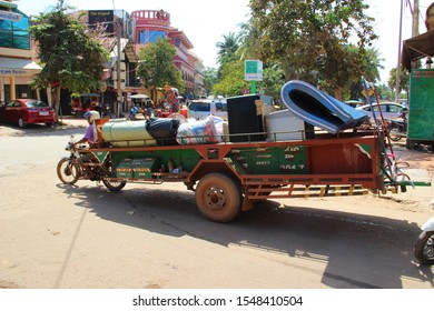 Siem Reap, Siem Reap Province / Cambodia - October 27 2019: moto pulling a big trailer. A tuk tuk tuktuk with an overloaded trailer.