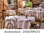 Siena, Italy - July 14, 2022: Dining tables on a streetside patio in Siena Italy	
