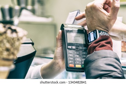 SIENA, ITALY - MARCH 17,2019: Man Uses Apple Pay System With Apple Watch 4 To Pay In A Shop. Apple Pay Is A Mobile Payment And Digital Wallet Service By Apple Inc