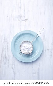 Sieve With Icing Sugar On A Plate