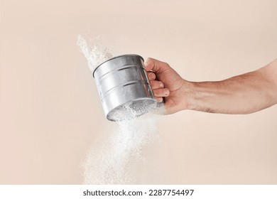 Sifting flour, hand holding a sieve with flour. Flour sifting process - Powered by Shutterstock