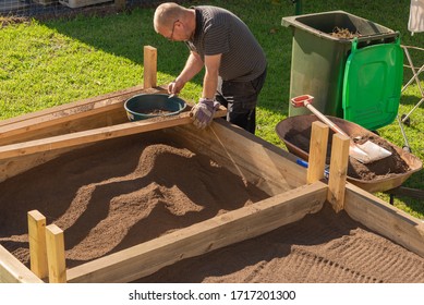 Sifting Soil Through A Garden Sieve To Remove Rubbish