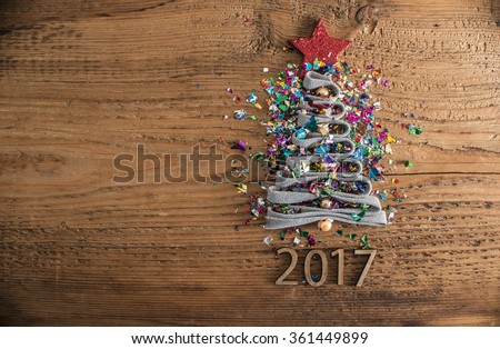 Sigh symbol Christmas Tree from a lot colorful confetti, lace and red star toy on old retro vintage style wooden texture background Empty copy space for inscription Idea of merry new year 2017 holiday