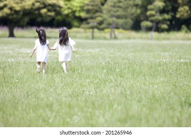 The Sight Of The Back Of 2 Girls Running Hand In Hand