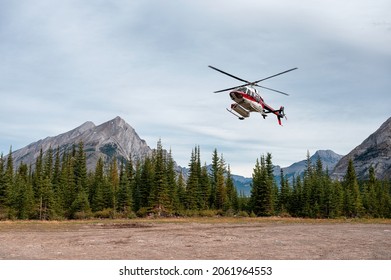 Sightseeing helicopter flying and landing to the ground in Banff national park, Canmore, Canada