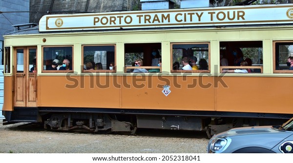 Sightseeing tourist tram on the street in Old\
Town. Portugal, Porto, September 25,\
2021