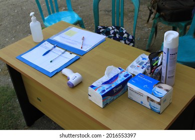 Sigi Regency, Central Sulawesi, Indonesia - April 20th, 2021: Portable Thermogun, Tissue Box, Liquid Hand Sanitizer, Air Sanitizer Spray, And A Box Of Face Mask. Some Healthcare On The Table 