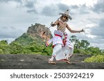 SIGIRIYA, SRI LANKA - JULY 16, 2024 : A Ves Dancer, also known as a Kandyan Dancer or Up Country Dancer performs at Sigiriya in Sri Lanka. In the background stands Sigiriya Rock.