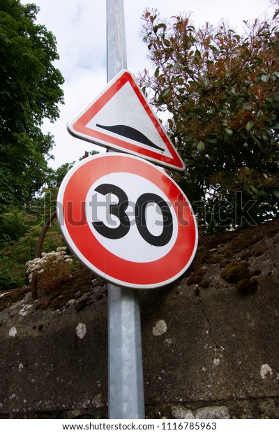              Sign of 30 speed limit and hump\
sign on the road                 \
