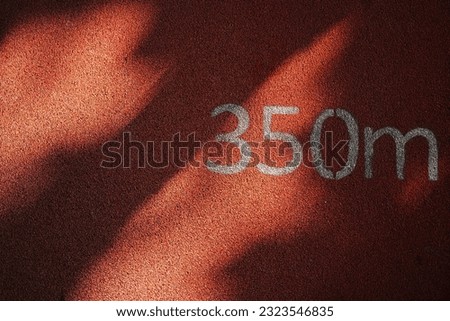 A sign of the 350 meters on a running track with sunlight