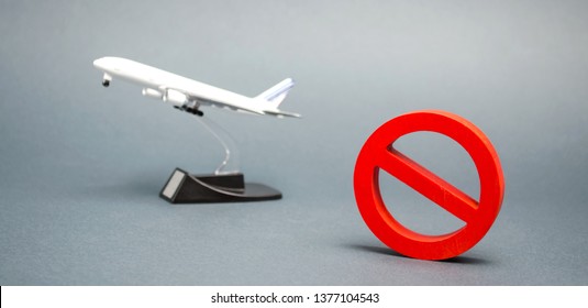 The sign of the ban and a miniature toy aircraft. Ban on flights of civil aircraft. Forbidden zone. Stop symbol. Bans on airport construction. Plane. Night flights. Law. Prohibition