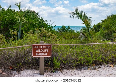 Sign and barrier rope at edge of protected wildlife habitat by trail on Sanibel Island along the Gulf Coast of Florida. Foreground focus. - Shutterstock ID 2016348812