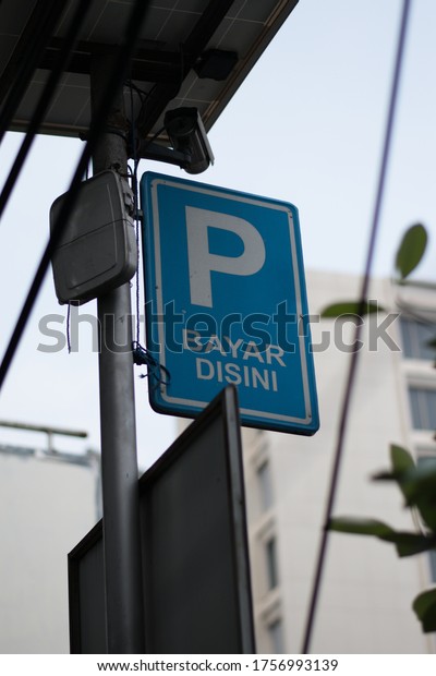 The sign of \'\'bayar di sini\'\'\
means \'\'pay here\'\' to pay the parking at the side road in\
Jakarta.