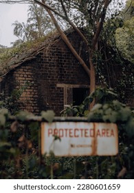 A sign board that shows Protected Area in front of a haunted building - Shutterstock ID 2280601659