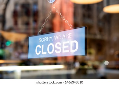 A sign board through the glass of store window. We are open, Sorry we are closed.  - Shutterstock ID 1466348810