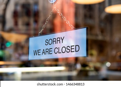 A sign board through the glass of store window. We are open, Sorry we are closed.  - Shutterstock ID 1466348813