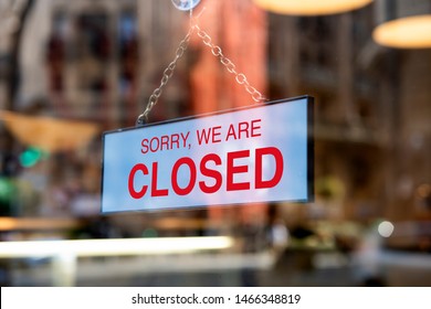 A sign board through the glass of store window. We are open, Sorry we are closed.  - Shutterstock ID 1466348819