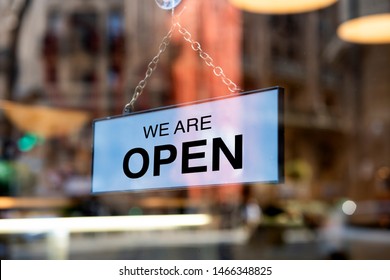 A sign board through the glass of store window. We are open, Sorry we are closed.  - Shutterstock ID 1466348825