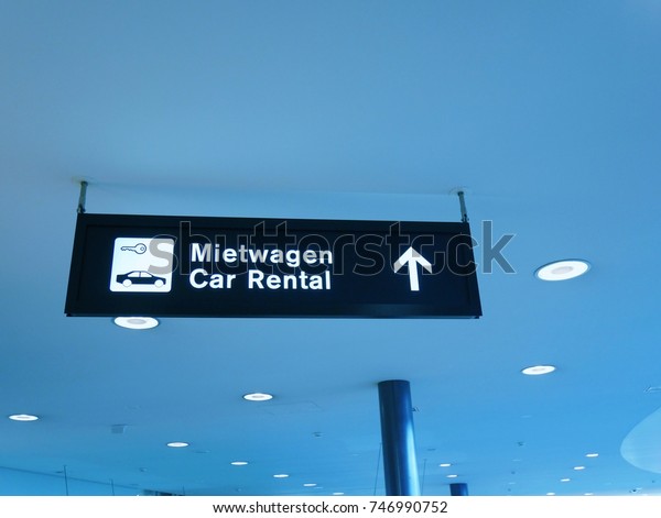 Sign of car rental with German language at the\
public airport,blue\
background