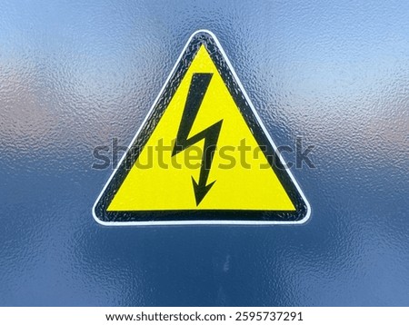 A sign caution electrical voltage is affixed to a metal door.