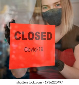 Sign Closed Covid 19 Lockdown On Shop Front Entrance Door As New Normal Shutdown. Woman In Protective Medical Mask Gloves Hangs Closed Sign On Window Of Cafe Restaurant. Lockdown Square Crop.