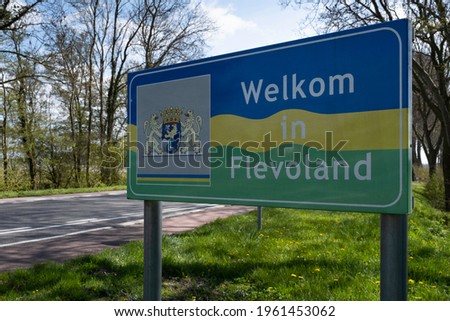 Sign with a coat of arms along the road in the dutch language to welcome people to the province of Flevoland near the municipality of Lemmer ('Welkom in Flevoland') 