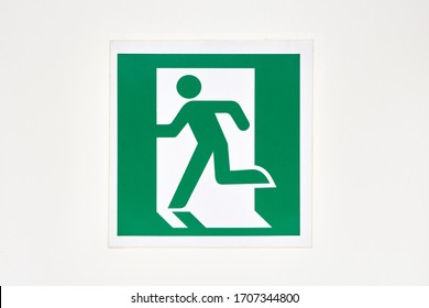 The sign of the direction to the evacuation exit on the wall in the shopping center is green - Shutterstock ID 1707344800