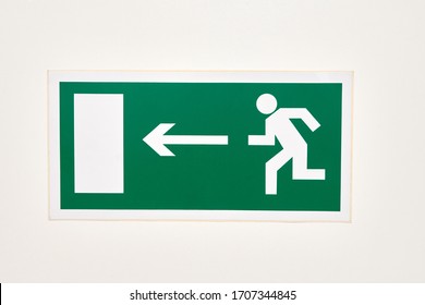 The sign of the direction to the evacuation exit on the wall in the shopping center is green - Shutterstock ID 1707344845