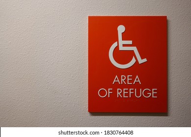 A sign in a hallway in an apartment complex that says Area of Refuge with a wheelchair symbol on it that is an emergency gathering area for disabled people. - Shutterstock ID 1830764408