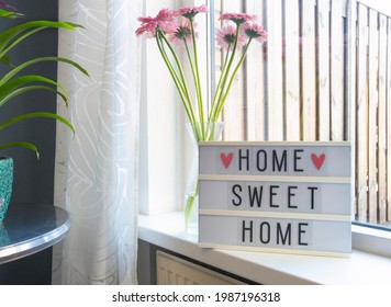 Sign Home Sweet Home Text On Lightbox ,windowsill Near Window With Pink Flowers, Decorative Frame Modern Interior Background, Stylish House Cozy Corner In Lovely Living Room Summer