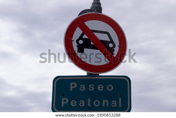 Sign indicating not allowed cars and in spanish :\
pedestrian walk.