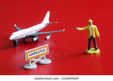 A sign with the inscription arrested next to a toy airliner and a bailiff on a red background. The concept of judicial arrest of aircraft and property of Russian oligarchs. Close-up.