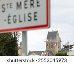 sign with the inscription STE MERE EGLISE indicating a site of the D-DAY D-DAY landing in WWII and bell tower