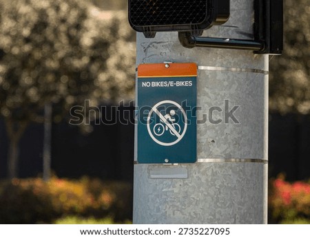 A sign at an intersection stating No Bikes or E Bikes 